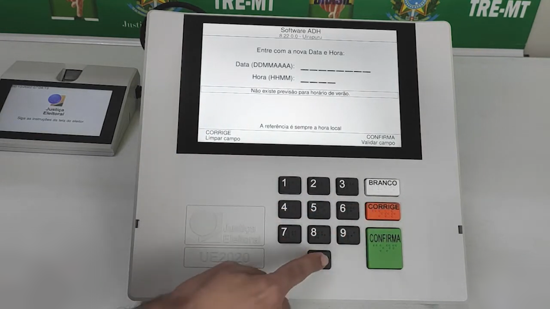 Imagem de uma urna eletrônica, exibindo a tela de ADH (ajuste de data e hora)uste  